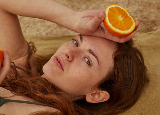Scalp sun protection with Dakmatter's UV defense spray placed on a natural surface, emphasizing hair and skin care.